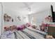 Bedroom featuring white walls, striped rug, and a ceiling fan at 10080 Se 68Th Ct, Belleview, FL 34420