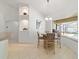 Dining Area has a modern chandelier and bay window overlooking pool at 10080 Se 68Th Ct, Belleview, FL 34420