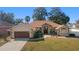 An inviting home featuring stone accents, manicured landscaping, and an attached two-car garage at 10080 Se 68Th Ct, Belleview, FL 34420