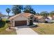 A charming single-Gathering home features a manicured lawn, stone accents, and a two-car garage at 10080 Se 68Th Ct, Belleview, FL 34420