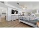 Spacious main bedroom featuring a tray ceiling, ceiling fan, wood-look floors, and ample natural light at 10080 Se 68Th Ct, Belleview, FL 34420