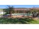 A screened-in pool is flanked by palm trees and paver landscaping, offering a private oasis at 10080 Se 68Th Ct, Belleview, FL 34420