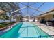 Long in ground swimming pool inside screen enclosure featuring concrete deck and backyard views at 10080 Se 68Th Ct, Belleview, FL 34420