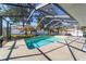 Enclosed swimming pool with a screened enclosure surrounded by lush landscaping at 10080 Se 68Th Ct, Belleview, FL 34420