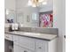 Well-lit bathroom featuring a large mirror, neutral countertop, and a floral-themed shower curtain at 10255 Se 178Th Pl, Summerfield, FL 34491