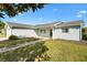 Charming single-story home featuring light blue siding, a well-maintained lawn, and a welcoming walkway to the front door at 10255 Se 178Th Pl, Summerfield, FL 34491