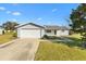 Inviting single-story home with an attached two-car garage, manicured lawn, and concrete driveway on a sunny day at 10255 Se 178Th Pl, Summerfield, FL 34491