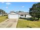 Charming single-story home with a well-kept lawn, mature trees, and a convenient two-car garage at 10255 Se 178Th Pl, Summerfield, FL 34491