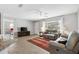 Bright living room with hardwood floors, a cozy seating area, a ceiling fan, and a view of the entryway at 10255 Se 178Th Pl, Summerfield, FL 34491