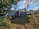 A view of the home's backyard, showing the house siding and a screened-in porch area at 10823 Sw 83Rd Ave, Ocala, FL 34481