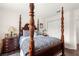 Bedroom featuring a four poster bed, wood floors, Zebra patterned accessories, and bedside table at 11221 Sw 71St Ct, Ocala, FL 34476