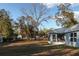 Backyard view showcasing the home's screened-in porch and expansive yard at 12164 Se 85Th Ct, Belleview, FL 34420