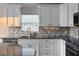 Close-up of a bright kitchen with sleek countertops, tile backsplash, and ample cabinet space at 12164 Se 85Th Ct, Belleview, FL 34420