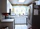 Cozy kitchen featuring white cabinetry, stainless steel appliances, and a garden window at 12330 Sw 43 St Rd, Ocala, FL 34481