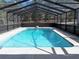 Screened in swimming pool with sparkling blue water and concrete surround at 12330 Sw 43 St Rd, Ocala, FL 34481