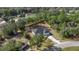 Home with a dark roof, surrounded by lush trees, and a long driveway at 14 Water Track Ct, Ocala, FL 34472