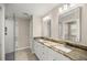 Bathroom showcasing dual sinks with granite countertops, framed mirrors, and a glass-enclosed shower at 14 Water Track Ct, Ocala, FL 34472