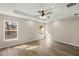 Bright bedroom with wood-look floors, ceiling fan, and plenty of natural light from the large windows at 14 Water Track Ct, Ocala, FL 34472