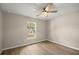 Bright bedroom featuring wood-look floors and a ceiling fan, with plenty of natural light from the window at 14 Water Track Ct, Ocala, FL 34472