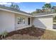 Inviting front entrance with freshly landscaped garden and a modern black front door at 14 Water Track Ct, Ocala, FL 34472