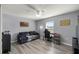 Comfortable bedroom featuring gray walls, wood floors, a sofa, desk, and a ceiling fan at 14560 Sw 25Th Ter, Ocala, FL 34473