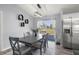 Cozy dining area featuring a modern light fixture, table with chairs, and stainless steel refrigerator at 14560 Sw 25Th Ter, Ocala, FL 34473