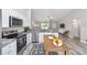 Modern kitchen with stainless steel appliances, white cabinets, granite countertops, and wooden table at 17094 Sw 39Th Cir, Ocala, FL 34473