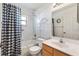 Bright bathroom featuring a shower-tub combo, white vanity, and black-and-white checkered shower curtain at 17755 Se 117Th Cir, Summerfield, FL 34491