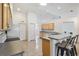 Bright kitchen with a breakfast bar, tile flooring, and neutral cabinetry for a clean look at 17755 Se 117Th Cir, Summerfield, FL 34491