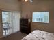 Bright bedroom with a dresser, large windows, and access to the screened patio at 1917 Nw 50Th Cir, Ocala, FL 34482