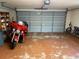 Spacious garage includes a red motorcycle, bicycles and storage shelving, offering plenty of room for parking and hobbies at 1917 Nw 50Th Cir, Ocala, FL 34482