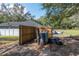 Equipment in a fenced-in backyard, with a glimpse of outdoor seating and a treed landscape at 2045 Marion County Rd, Weirsdale, FL 32195