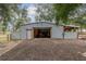 Large metal barn with an open door showcasing storage space and the surrounding outdoor area at 2045 Marion County Rd, Weirsdale, FL 32195