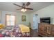 Cozy bedroom features a ceiling fan, dresser, and wood flooring at 2045 Marion County Rd, Weirsdale, FL 32195