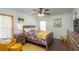 Bright bedroom featuring a floral-themed bed set, wooden floors, and cozy yellow armchair at 2045 Marion County Rd, Weirsdale, FL 32195