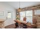 Dining area with stone accent wall, a modern light fixture, and a unique wooden table and chairs at 2045 Marion County Rd, Weirsdale, FL 32195