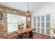 Dining area with unique rustic table, brick accent wall and views of the backyard at 2045 Marion County Rd, Weirsdale, FL 32195