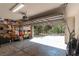 Garage with open door revealing a view of a lush, wooded backyard landscape at 2045 Marion County Rd, Weirsdale, FL 32195