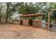 View of horse shelter featuring individual gated stalls, adjacent to a horse pen at 2045 Marion County Rd, Weirsdale, FL 32195