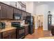 Modern kitchen featuring dark cabinets, granite countertops, and stainless steel appliances at 2045 Marion County Rd, Weirsdale, FL 32195