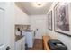 Well-lit laundry room with modern washer and dryer, cabinetry, utility sink, and decorative artwork at 2045 Marion County Rd, Weirsdale, FL 32195