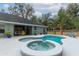 Backyard pool and hot tub with an outdoor seating area, landscaped with potted plants for a serene atmosphere at 2045 Marion County Rd, Weirsdale, FL 32195