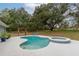 Inviting kidney-shaped pool with an attached spa and covered pergola, perfect for outdoor relaxation and entertaining at 2045 Marion County Rd, Weirsdale, FL 32195