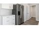 Well-lit kitchen with stainless steel refrigerator, white cabinetry, and gray wood floors at 2680 Sw 144 Ct, Ocala, FL 34481