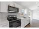 Modern kitchen features stainless steel appliances, white cabinets, and a view through sliding doors at 2680 Sw 144 Ct, Ocala, FL 34481