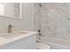 Bright bathroom featuring a modern vanity and a shower-tub combination with elegant marble-style tile surround at 2686 Sw 144Th Ct, Ocala, FL 34481