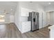 Bright kitchen with white cabinets, stainless steel refrigerator, and stylish gray wood-look flooring at 2746 Sw 147Th Ct, Ocala, FL 34481