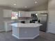 Bright kitchen featuring white cabinets, an island, modern appliances, and neutral countertops at 28 Pine Trace Run, Ocala, FL 34472