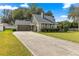 Charming home featuring a stone facade, attached garage and a long driveway on a lush green lawn at 2840 Se 35Th St, Ocala, FL 34471