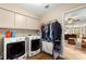 Laundry room featuring washer and dryer, storage cabinets, and utility sink, located off the kitchen at 2840 Se 35Th St, Ocala, FL 34471